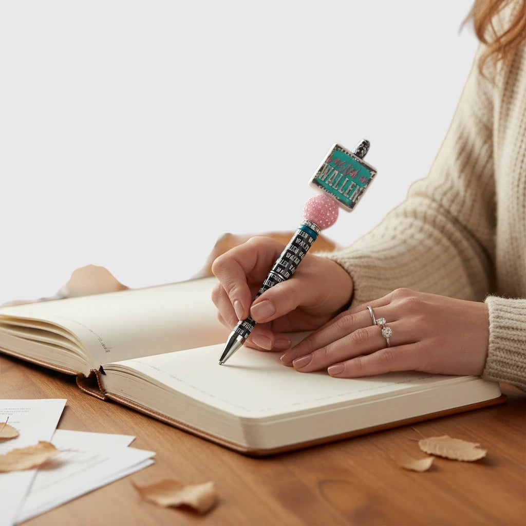 THE SALTY CHIC decorative beaded pen with Wasted on Wallen topper and pink bead being used to write in a journal.