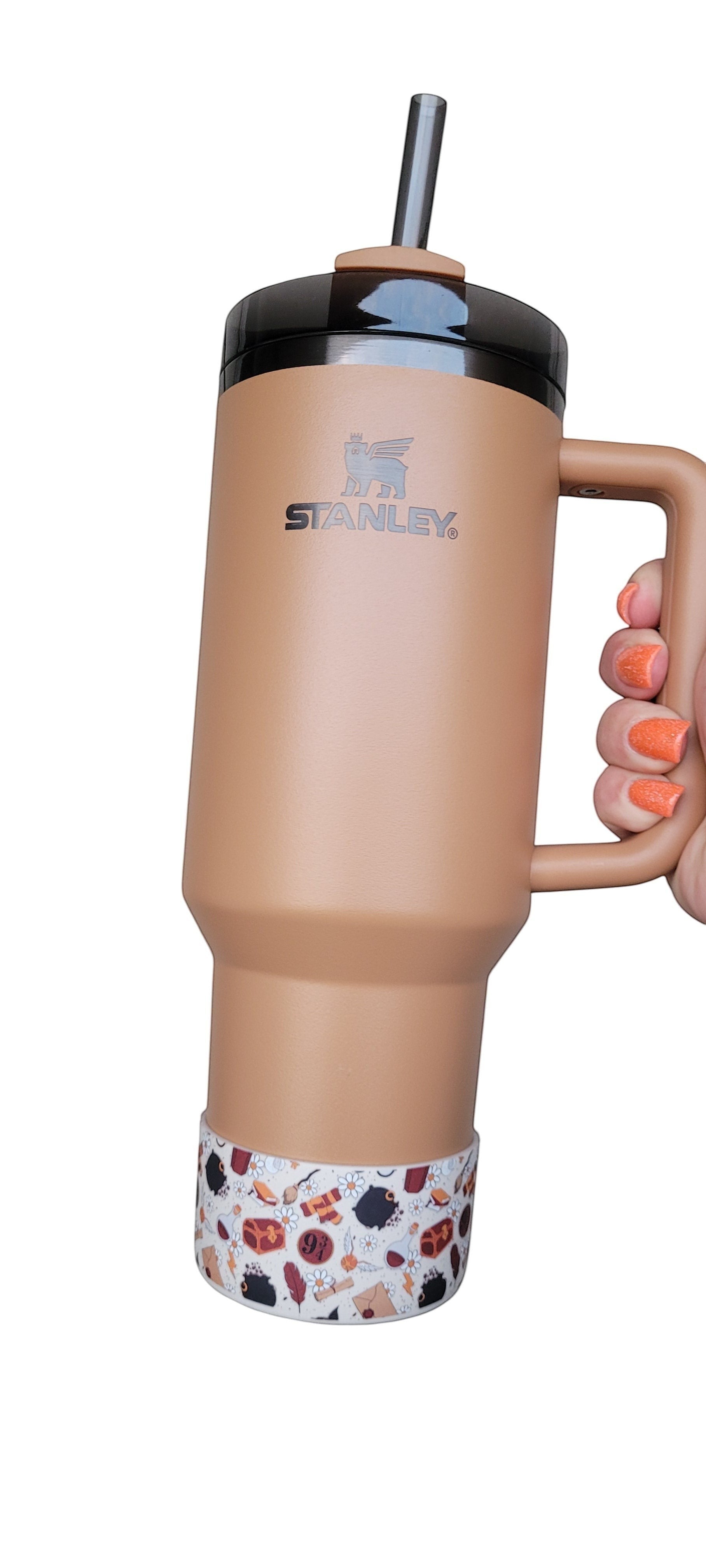 THE SALTY CHIC Harry Potter themed silicone tumbler boot with magical icons on a tan Stanley cup
