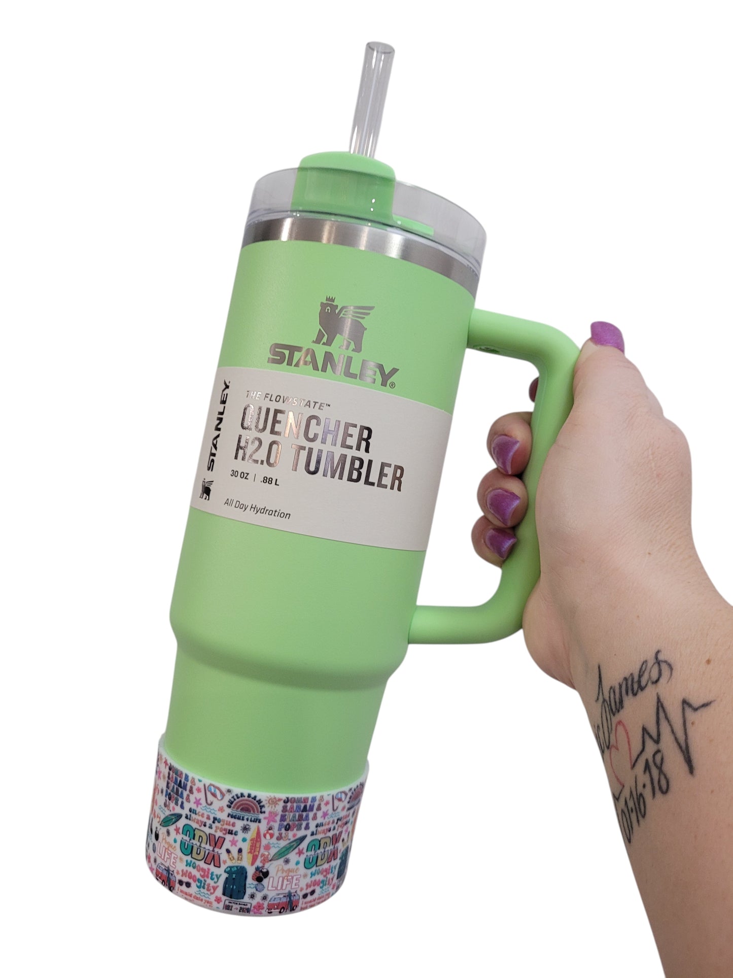 THE SALTY CHIC Outer Banks tumbler boot on a light green Stanley Quencher cup held by a hand