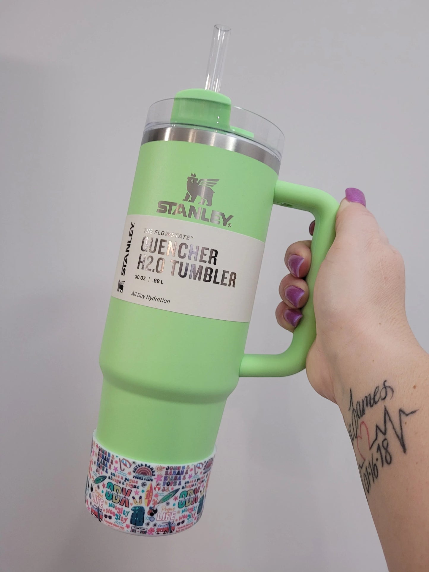 THE SALTY CHIC Outer Banks tumbler boot featuring a colorful beach-themed pattern on a light green Stanley tumbler