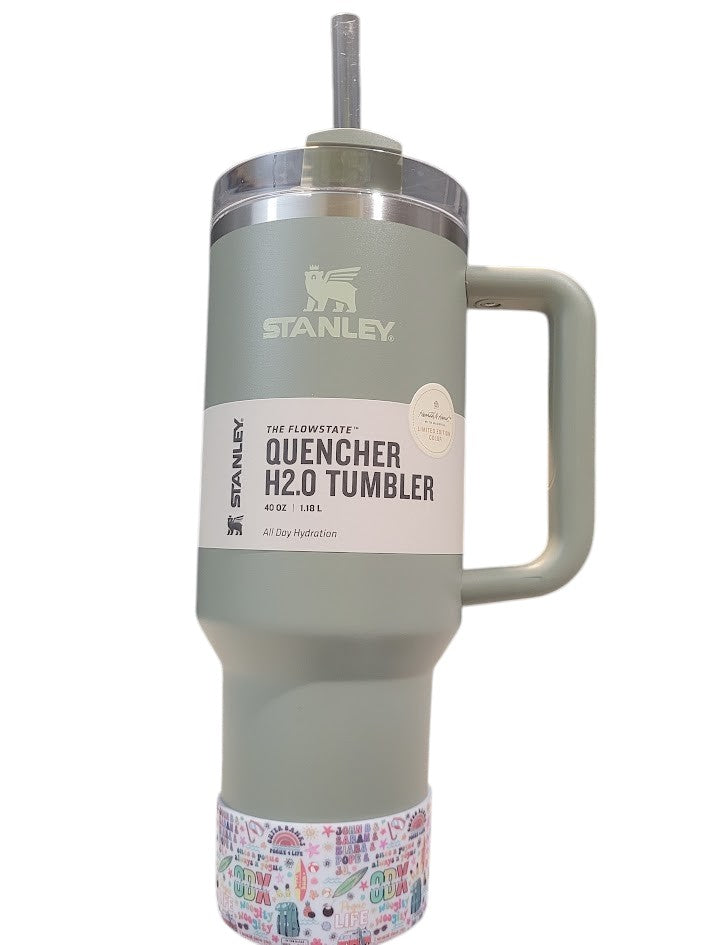 THE SALTY CHIC Outer Banks tumbler boot on a sage green Stanley Quencher H2.0 cup with colorful beach-themed pattern